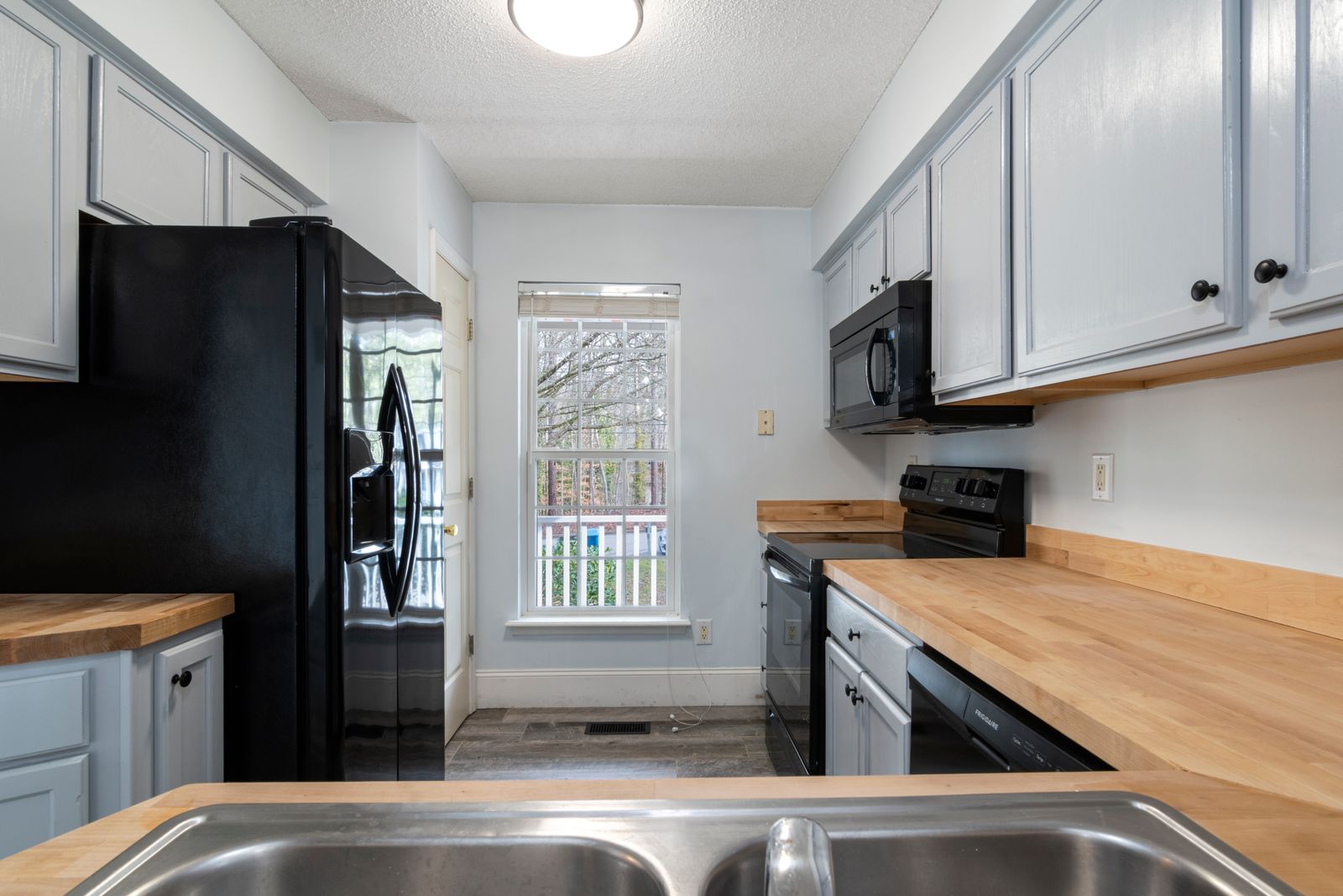 Bungalow kitchen with painted cabinetry, tile splashback and a chimney hood
