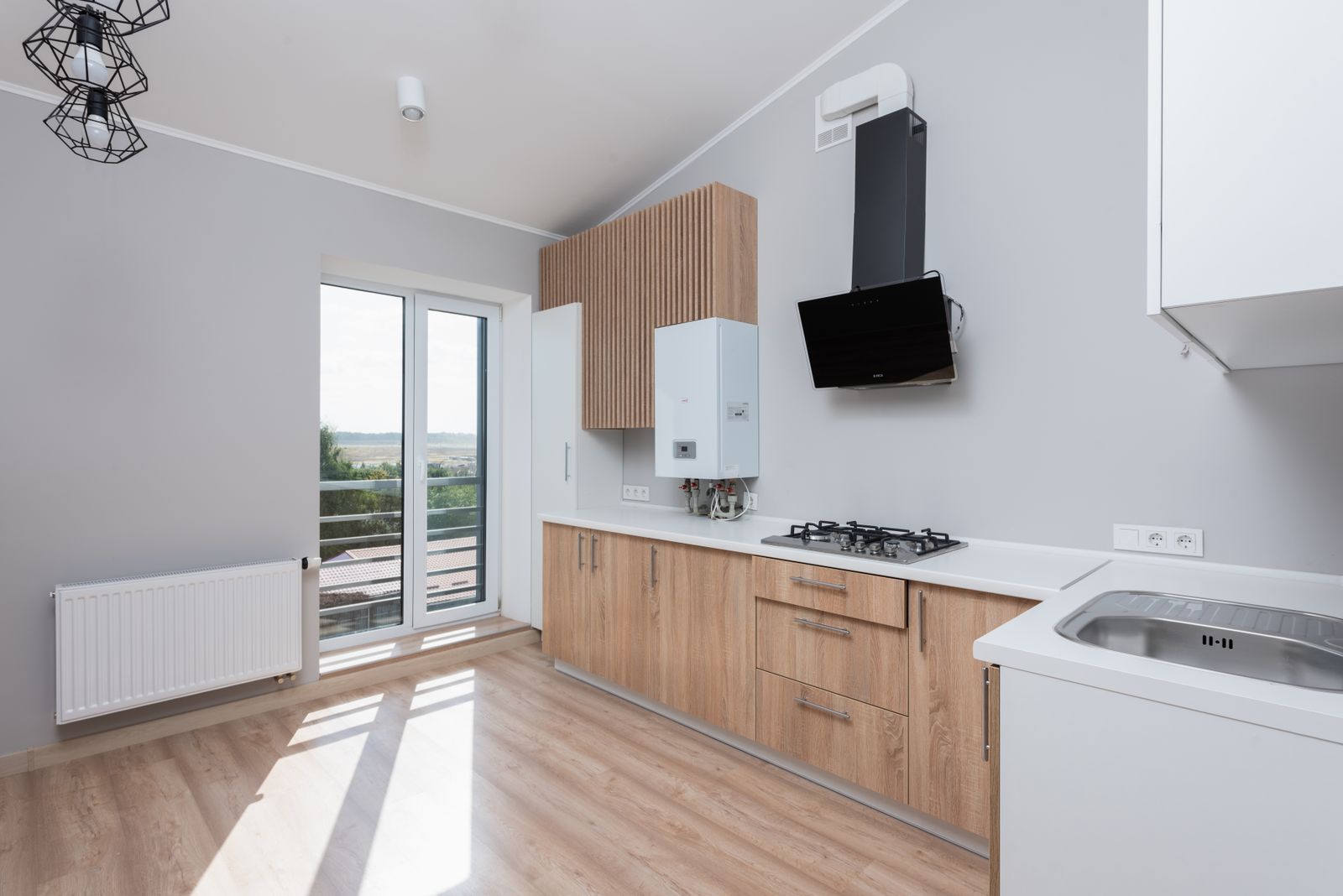 Daylit Scandinavian kitchen with pale wood cabinetry and a long counter run
